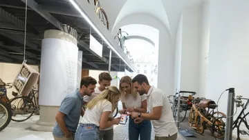Gruppe schaut Handy im Fahrradmuseum.