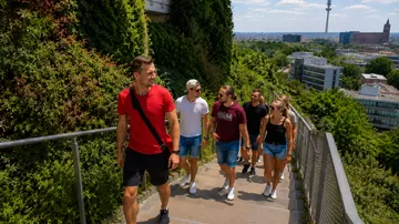 Gruppe geht Treppe in Stadtpark hinauf.