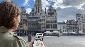 Person nutzt Handy auf europäischem Platz.