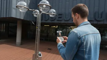 Person benutzt Handy vor einem Museumseingang.
