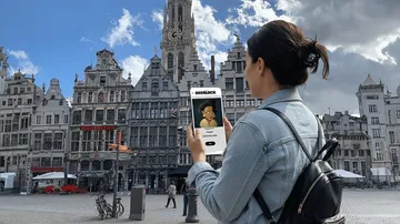 Woman using phone app in city square.