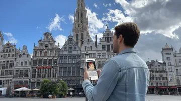 Mann nutzt Augmented-Reality-App auf Stadtplatz.