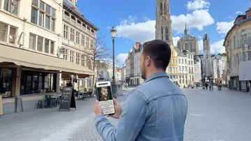 Man looking at phone in European square.