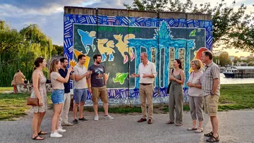 Group talking near wall with colorful graffiti.