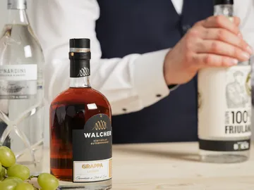 Walcher Grappa steht auf einem Tisch, während jemand einschenkt.