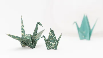 Three origami cranes on a white background.