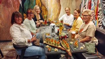 Gruppe von Frauen genießt Sushi im Restaurant.