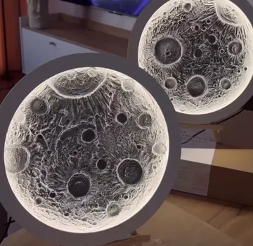 Circular moon lamps on wooden stands indoors.