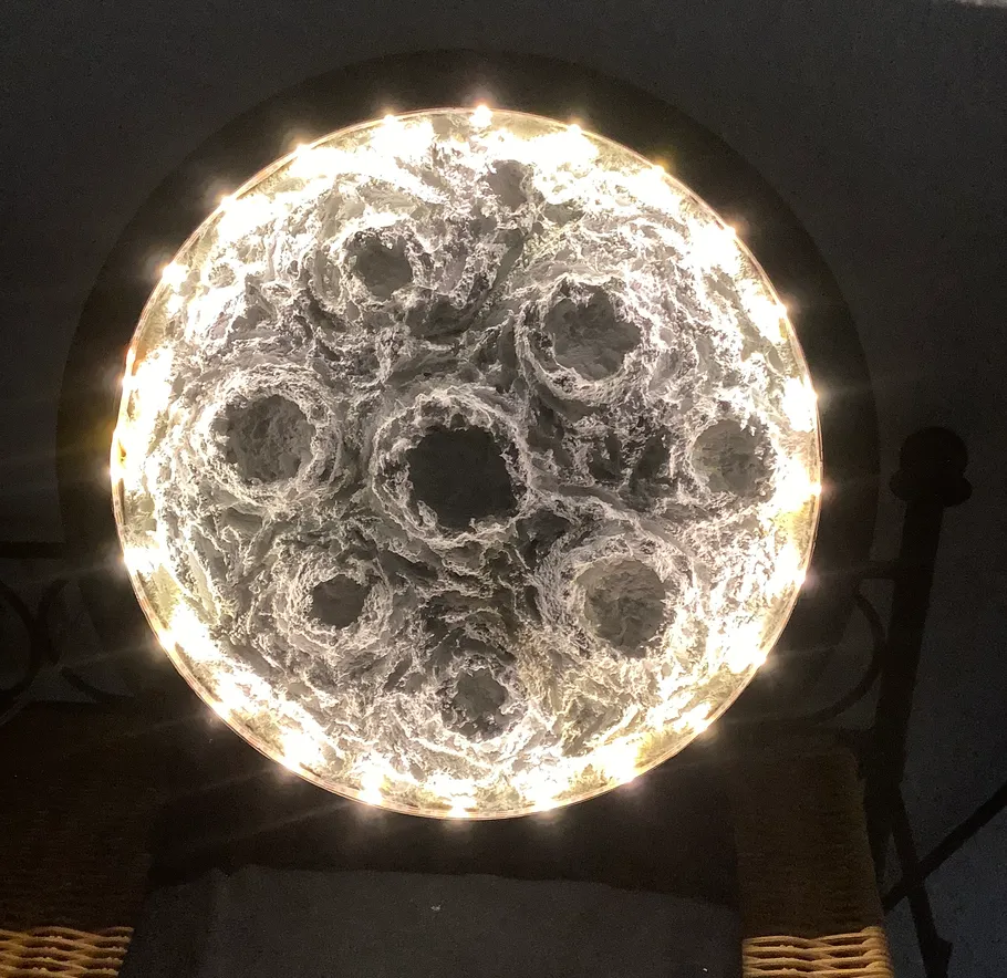 Runde Lampe mit komplexem Muster, leuchtet sanft.