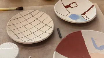 Dekorierte Keramikteller auf Holztisch.