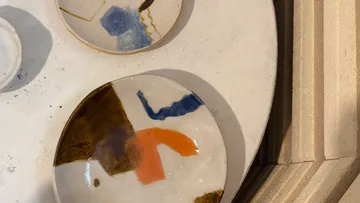 Zwei abstrakt gemusterte Keramikteller auf Tisch.
