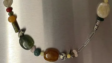 Colorful beaded necklace on a metal surface.