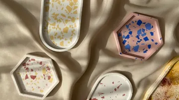 Bunte Terrazzo-Tabletts auf Stoffoberfläche.