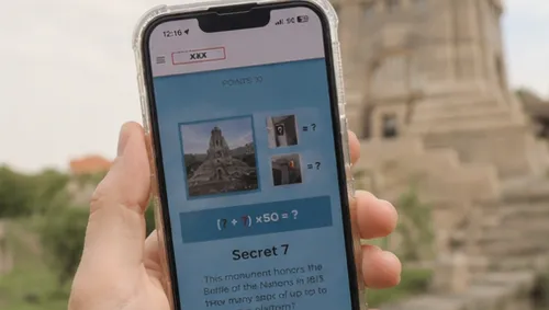Hand hält Handy mit Monument auf Bildschirm.