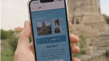 Person hält Handy mit Puzzle-App.