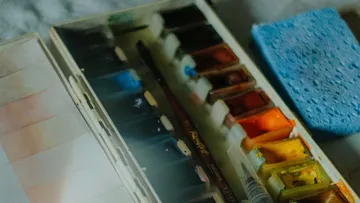 Watercolor palette with pigments and sponge.