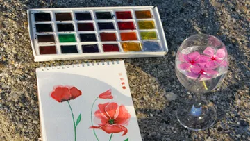Paints, watercolor painting, glass with flowers.