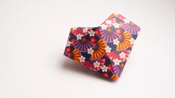 Origami-Herz aus gemustertem Papier gefaltet.