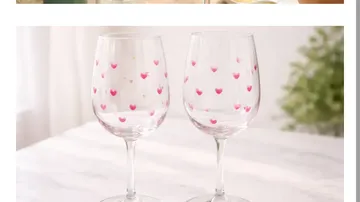 Zwei Gläser mit Herzdesigns auf Tisch.