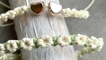Gewobene Armbänder auf Holzoberfläche.