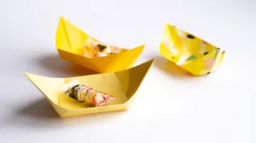 Yellow paper boats with candies inside.