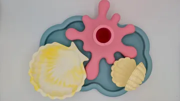 Bunte Muscheln und rosa Dekor auf blauer Basis.