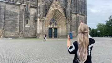 Person zeigt auf Kathedraleneingang.