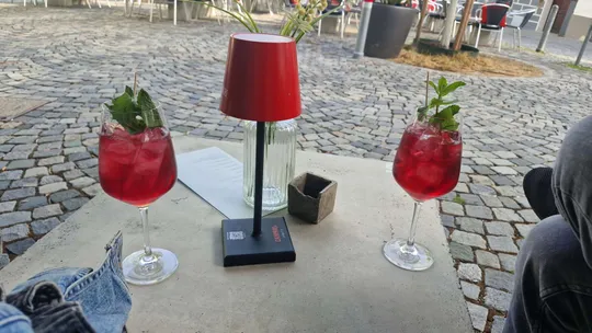 Zwei rote Getränke auf Außentisch.