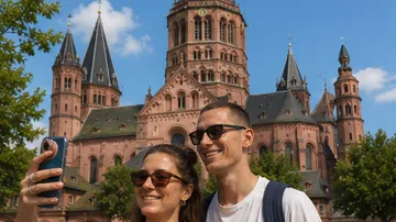 Zwei Personen machen Selfie vor Kathedrale.