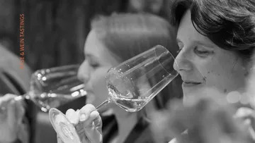 Zwei Frauen riechen Wein bei Verkostung.