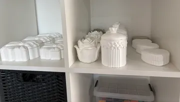White ceramic containers on a shelf.