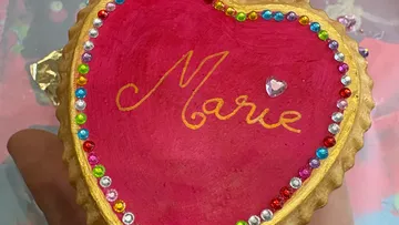 Herzförmiger Keks mit "Marie" in lebhaften Farben.