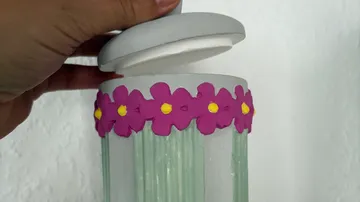 Hand opening jar with flower design.