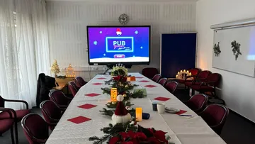 Weihnachtlich dekorierter Konferenztisch.