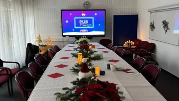 Decorated table set for Christmas meeting.