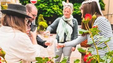 People toasting outdoors with glasses of champagne.