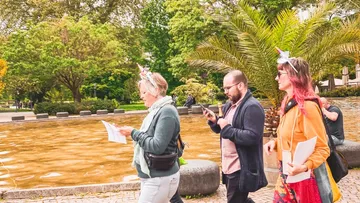 People with papers walking in a park.
