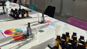 Parfümflaschen auf weißem Tisch angeordnet.