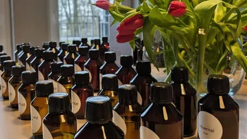 Flaschen und Blumen auf Tisch drinnen.