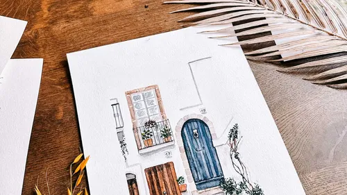 Watercolor painting of a house on table.