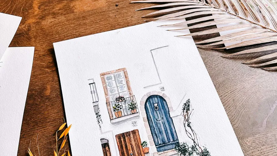 Watercolor painting of a house on table.