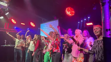 People singing on stage at a karaoke night.