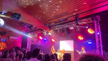 People applauding on stage at a concert.