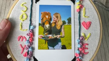 Foto einer Frau, die ein Pferd füttert, umrahmt von Stickerei.
