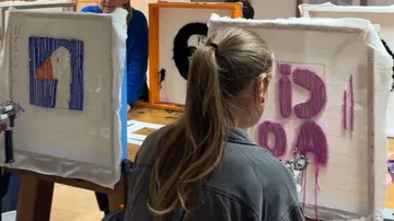 Person crafting artwork in a studio.