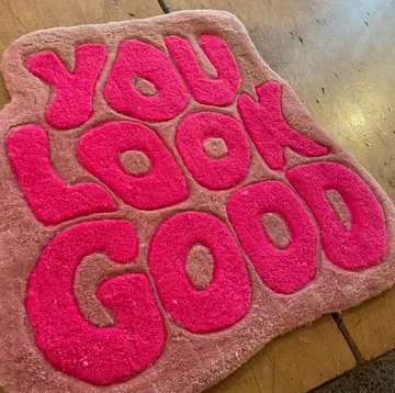 Rosa Teppich mit 'YOU LOOK GOOD' Text.