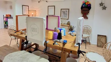 Bastelstudio mit Werkzeugen und bunten Garnen.