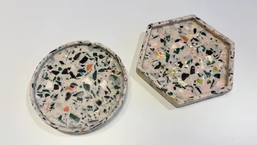 Runde und hexagonale Terrazzo-Untersetzer auf Tisch.