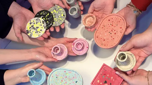 Hands hold colorful terrazzo items together.
