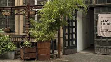 Eingang zu Töpferstudio mit Pflanzen draußen.